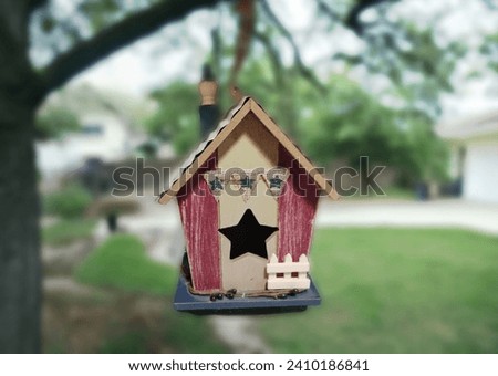 An American flag themed birdhouse with a star shaped hollow