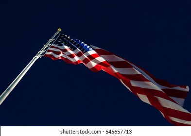 American Flag Under Spotlight Against Dark Sky