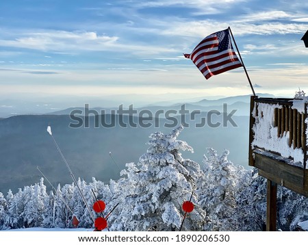 American flag waiving at the ski patrol house at the beautiful snow day at the Stowe Mountain Ski resort Vermont - December 2020