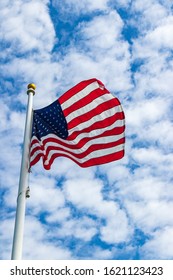 The American Flag Waves In The Wind As The Blue Sky Serves As A Back Drop.