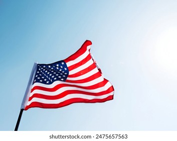 American flag waving against blue sky - Powered by Shutterstock