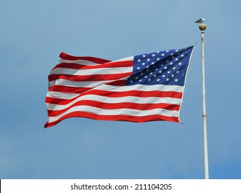 American flag waving in blue sky - Shutterstock ID 211104205