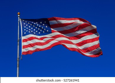 American Flag Waving In Clear Blue Sky