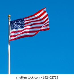An American flag waving in the clear blue sky