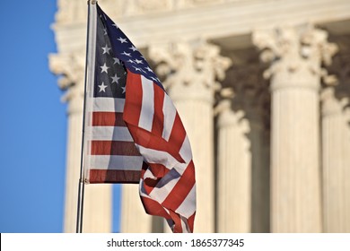 American Flag Waving In Front Of The U.S. Supreme Court Building Columns On Capitol Hill In Washington, DC