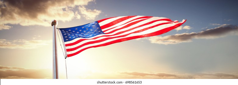 American flag waving over white background against panoramic view of golden fields