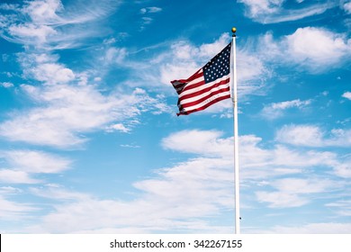 American Flag Waving Under A Blue Sky