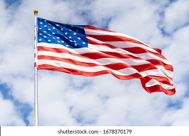 American Flag Waving In A White Clouded Sky