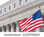 American flag waving in the wind in front of United States Court House in New York