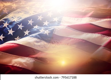 American Flag Waving In The Wind At Sunset Or Sunrise.