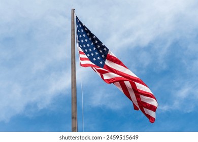American flag waving in the wind. Flag of the USA. National waving flag of united states on sky. Independence day. Patriotic symbol. American Flag for Memorial Day or 4th of July. Display patriotism