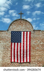 American Flag and Wooden Cross on a Red Brick Building