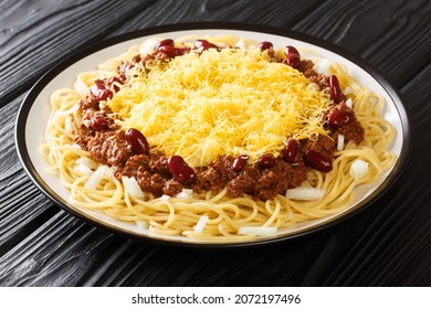 Amerikanische Küche Cincinnati Chilis mit Spaghetti, Cheddar Käse und Bohnen, Nahaufnahme in einem Teller auf dem Tisch. horizontal