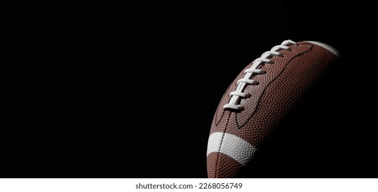 American football ball close up on black background. Horizontal sport theme poster, greeting cards, headers, website and app - Powered by Shutterstock