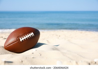 American Football Ball On Beach. Space For Text