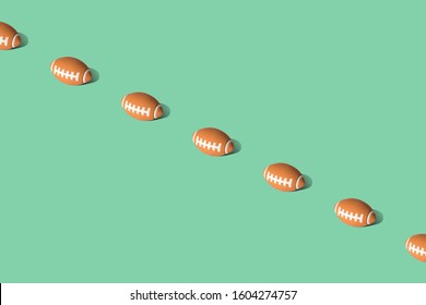 American football balls on green background minimal creative sport concept. Space for copy.
