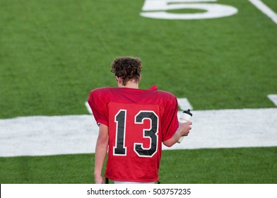 American Football Boy On Sidelines During Water During Game.