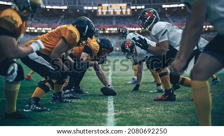 American Football Championship. Teams Ready: Professional Players, Aggressive Face-off, Ready for Pushing, Tackling. Competition Full of Brutal Energy, Power. Stadium Shot with Dramatic Light