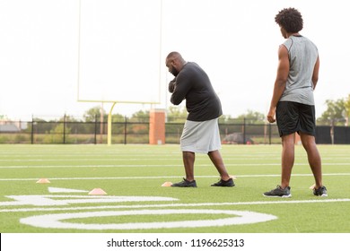 American Football Coach Training An Athlete.