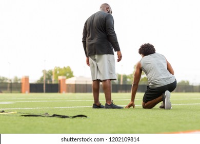 American Football Coach Training A Young Athlete.