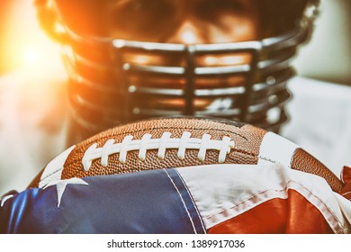 American football concept. The ball for the American football lies on the flag of America against the background of the portrait of the American football player. - Powered by Shutterstock