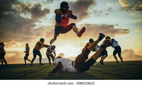 American Football Field Start Of Offensive Play With A Snap Pass: Successful Player Jumping Over Defense Running To Score Touchdown Points. Professional Athletes Compete Fight For Victory