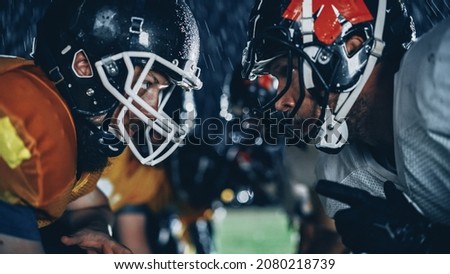 American Football Game Start Teams Ready: Close-up Portrait of Two Professional Players, Aggressive Face-off. Competition Full of Brutal Energy, Power, Skill. Rainy Night with Dramatic Light