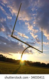 American Football Goal Posts And End Zone At Sunset Over Dramatic Cloudy Sky