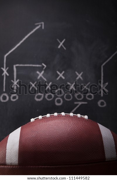 An\
American football and a hand drawn chalkboard\
play.