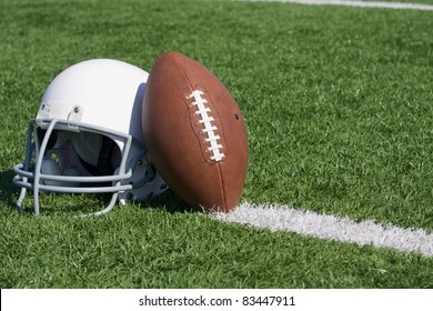 American Football And Helmet On The Field