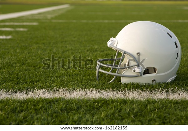 American\
Football Helmet on the Field with room for\
copy