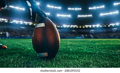 American Football Kickoff Game Start. Close-up Shot of an American Ball Standing on a Stadium Field Held by Professional Player. Preparation for Championship Game. - Powered by Shutterstock