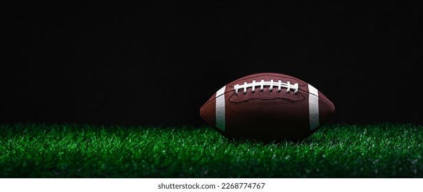 American football on green grass, on black background. Horizontal sport theme poster, greeting cards, headers, website and app
 - Powered by Shutterstock