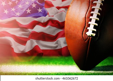 American football on green grass, on flag of United States of America background - Powered by Shutterstock