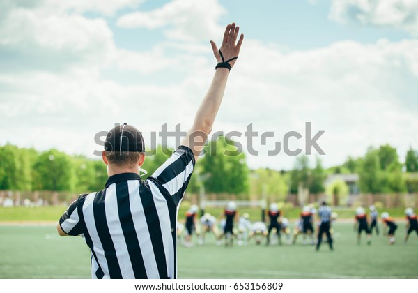 American Football played by young men with game\
official linesman\
referee