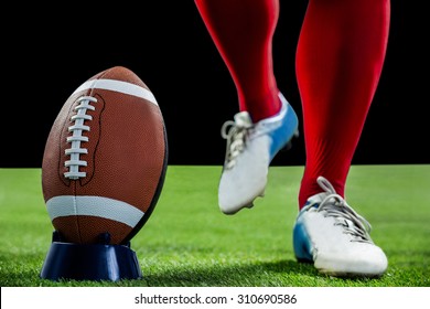 American football player being about to kick football on american football field - Powered by Shutterstock