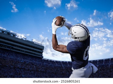 American Football Player catching a pass during a game. View from below as he tries to score a touchdown - Powered by Shutterstock