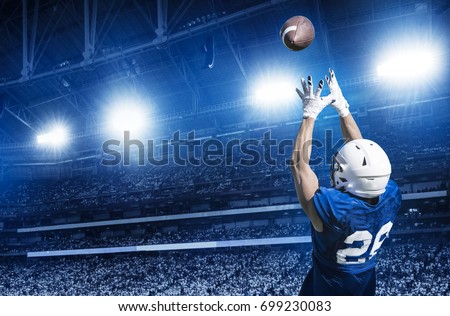 American Football Player Catching a touchdown Pass in a large stadium.