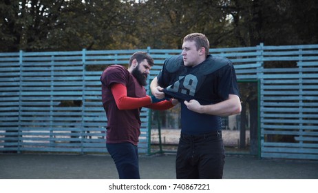 American Football Player Helping His Mate To Put On Jersey Before Game On Field