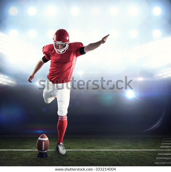 American Football Player Kicking Football Against Stock