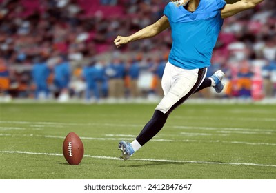 American football player kicking ball in the stadium field - Powered by Shutterstock