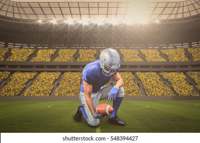 American football player kneeling while holding ball against large football stadium with fans in yellow with copy space 3d - Powered by Shutterstock