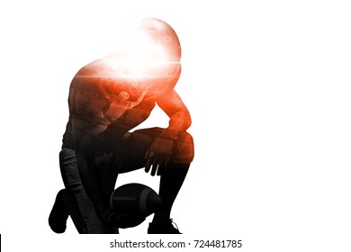 American football player kneeling while holding ball against black background - Powered by Shutterstock