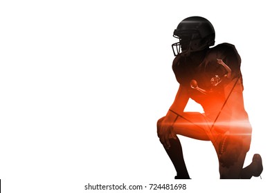 American football player looking away while kneeling against black background - Powered by Shutterstock