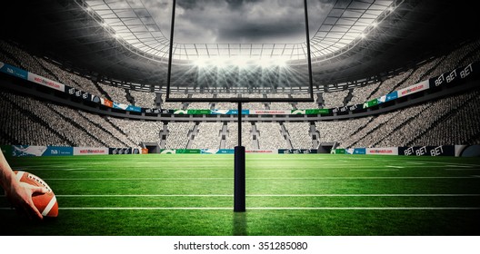 American Football Player Preparing For A Drop Kick Against American Football Arena