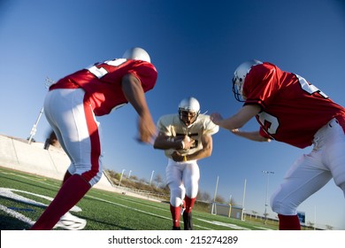 American football player running with ball at opposing team during competitive game (surface level, tilt) - Powered by Shutterstock