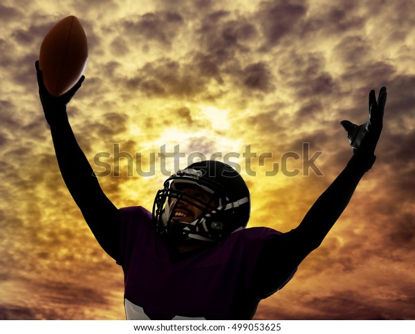 American football player silhouette on sky\
with clouds background