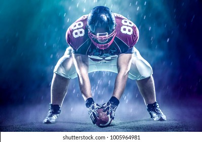 American Football Player Starting Football Game On Big Modern American Football Field With Lights And Flares At Night