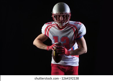American football player wearing helmet ready to throw ball on black background - Shutterstock ID 1264192138