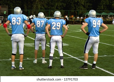 American Football Players On Sidelines At A Game Field.